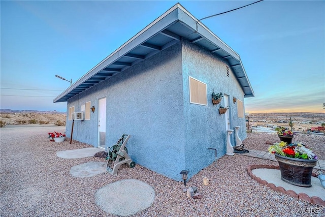 view of side of home with stucco siding