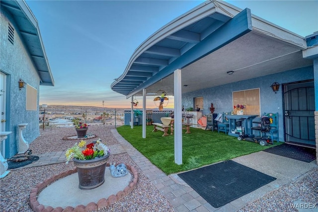 yard at dusk with a patio area and fence