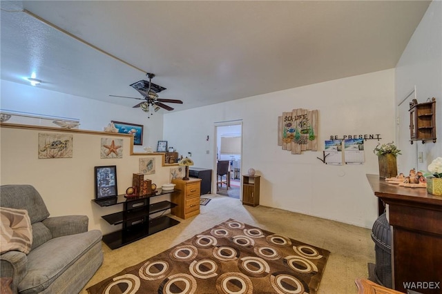 living area with a ceiling fan and light colored carpet