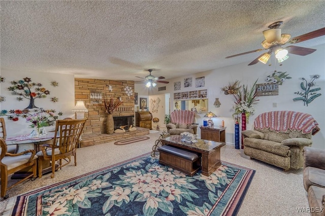 living room featuring a large fireplace, ceiling fan, a textured ceiling, and carpet flooring