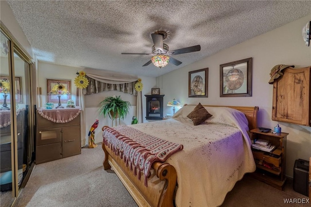 bedroom featuring a textured ceiling, lofted ceiling, a ceiling fan, a closet, and carpet