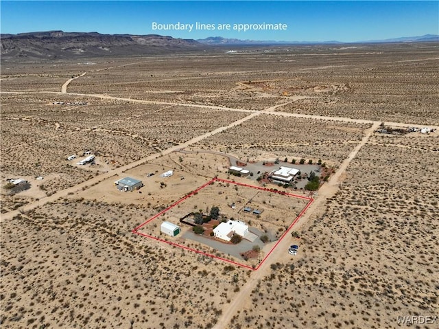 drone / aerial view featuring a mountain view, a desert view, and a rural view