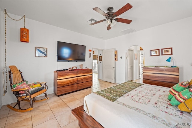 bedroom with a ceiling fan, light tile patterned floors, visible vents, and arched walkways