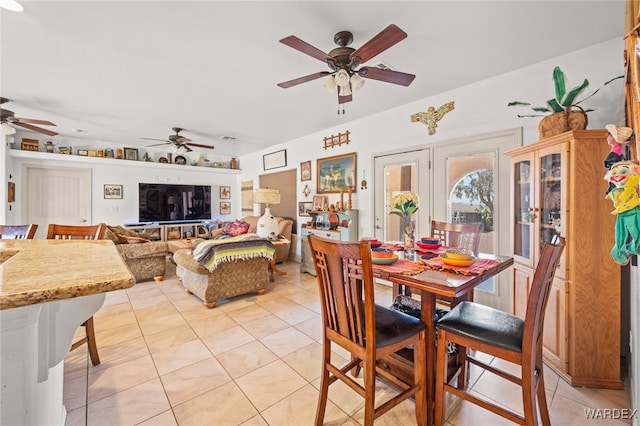 dining area with light tile patterned floors, french doors, and ceiling fan