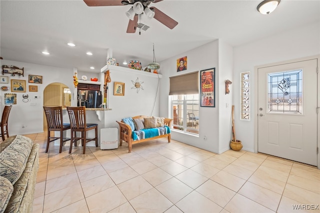 foyer with a ceiling fan, light tile patterned floors, recessed lighting, and arched walkways