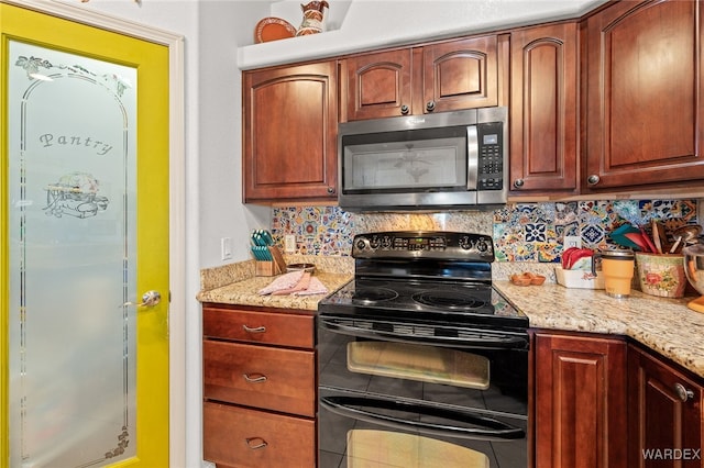 kitchen featuring stainless steel microwave, backsplash, double oven range, and light stone countertops