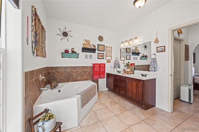 bathroom featuring a sink, a bath, double vanity, and tile patterned floors