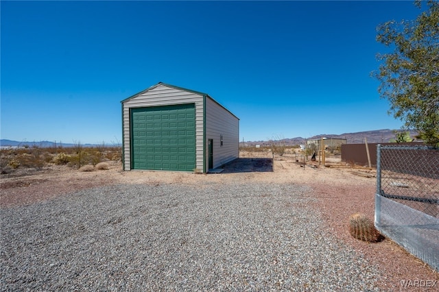 detached garage featuring fence and a mountain view