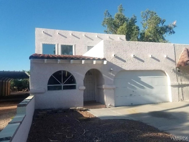 mediterranean / spanish home with a garage, driveway, a tile roof, and stucco siding