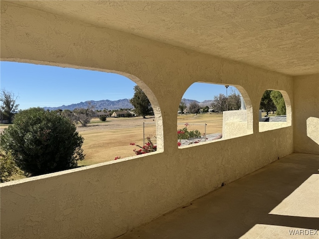 view of patio with a mountain view and a balcony