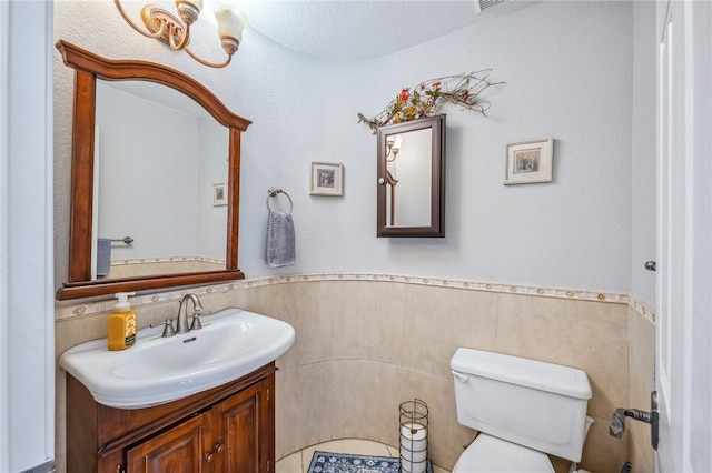 1878 E Fairway Bnd, Fort Mohave, AZ 86426 - half bathroom with vanity, tile walls, and a wainscoted wall