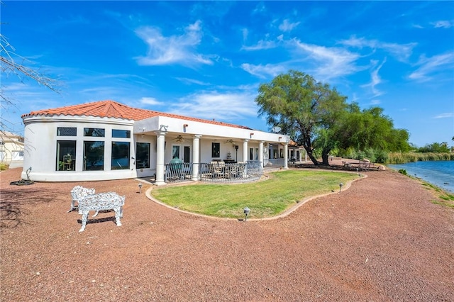 1878 E Fairway Bnd, Fort Mohave, AZ 86426 - rear view of property featuring a ceiling fan, stucco siding, a tile roof, a water view, and a lawn