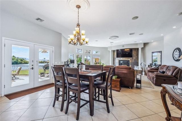 1878 E Fairway Bnd, Fort Mohave, AZ 86426 - dining room with light tile patterned flooring, a chandelier, french doors, and a tile fireplace