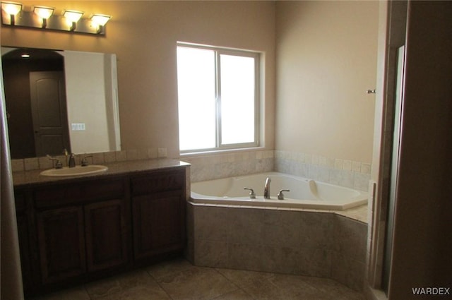 bathroom featuring tile patterned flooring, a garden tub, and vanity