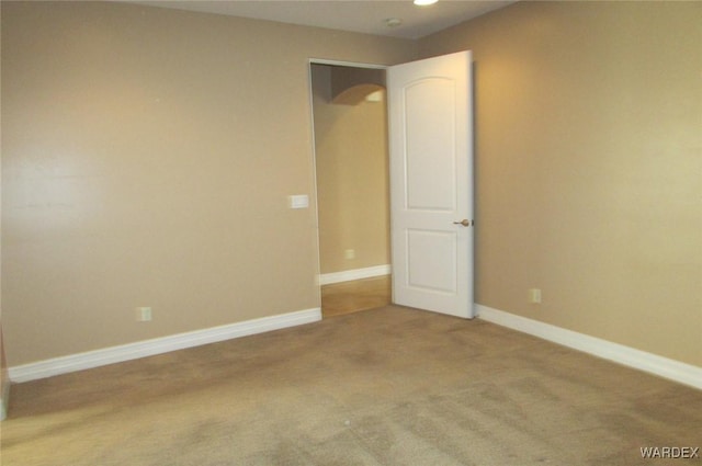 unfurnished room with carpet and baseboards