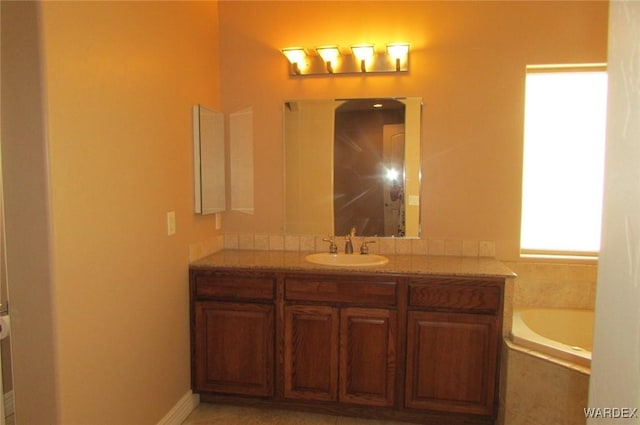 full bathroom featuring a garden tub and vanity