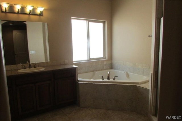 bathroom with a garden tub, tile patterned flooring, and vanity