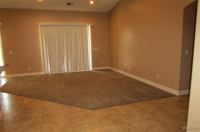 spare room featuring light carpet, baseboards, and visible vents