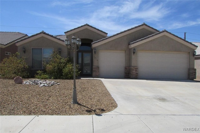 single story home featuring a garage, driveway, a tile roof, and stucco siding