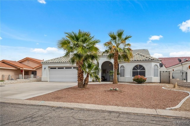 mediterranean / spanish-style house featuring a tile roof, a garage, driveway, and stucco siding