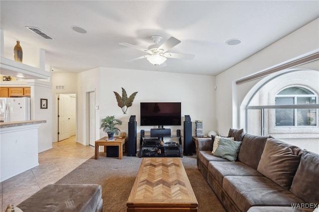 living area featuring light tile patterned floors, visible vents, and a ceiling fan