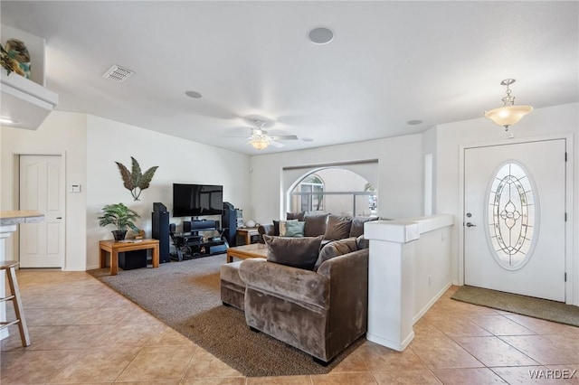 living room featuring a ceiling fan, a healthy amount of sunlight, visible vents, and light tile patterned floors