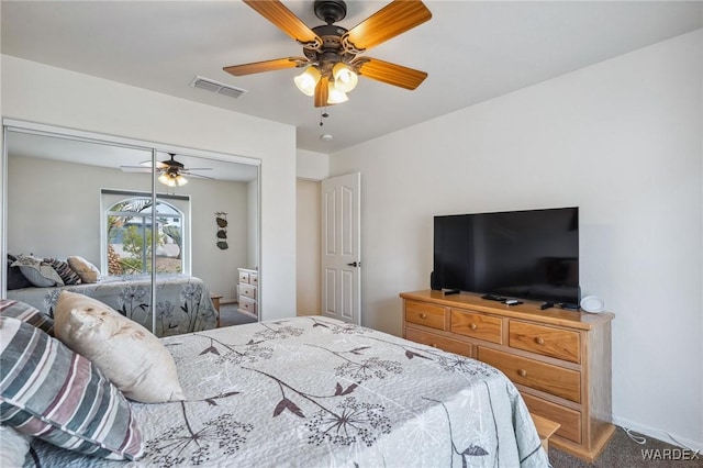 carpeted bedroom featuring a closet, visible vents, and ceiling fan