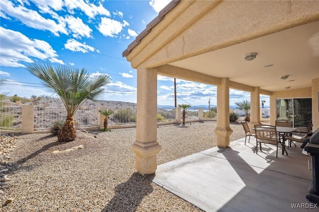 view of patio featuring fence and outdoor dining area