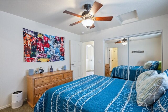 carpeted bedroom featuring baseboards, attic access, and a ceiling fan