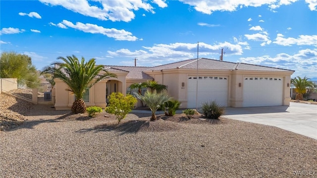 view of front of property with a garage, fence, a tile roof, concrete driveway, and stucco siding