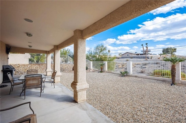 view of patio with outdoor dining space and fence