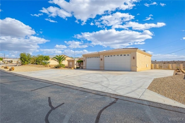 view of front of property with driveway, a tiled roof, and stucco siding