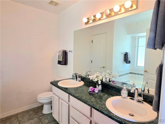 bathroom featuring visible vents, a sink, a bath, and tile patterned flooring