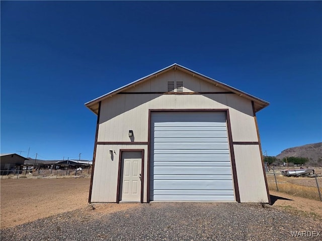 detached garage featuring fence and a mountain view