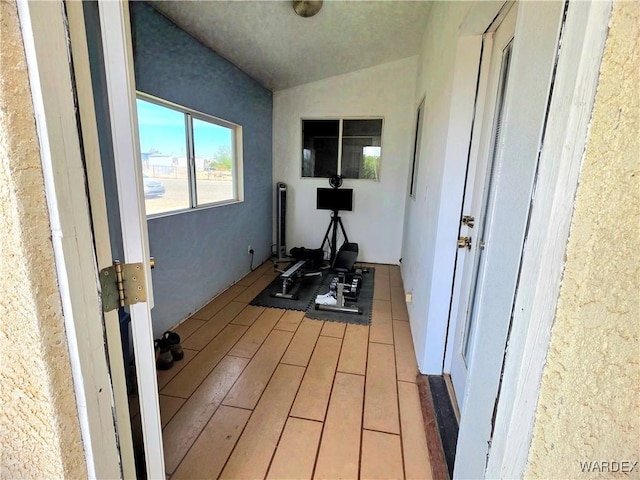 exercise room with vaulted ceiling