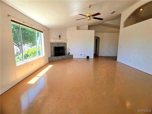 unfurnished living room featuring a ceiling fan, finished concrete flooring, lofted ceiling, a fireplace, and arched walkways