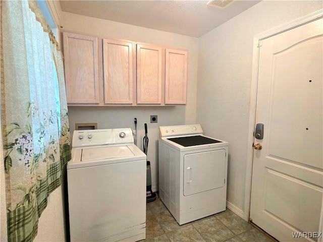 laundry area with washer and clothes dryer, cabinet space, and light tile patterned floors