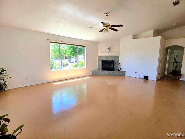 unfurnished living room featuring ceiling fan, visible vents, a tiled fireplace, arched walkways, and concrete flooring