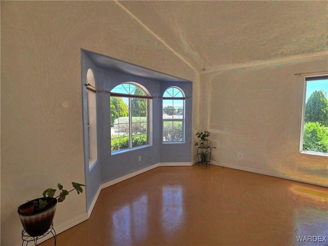 unfurnished room with baseboards and concrete floors