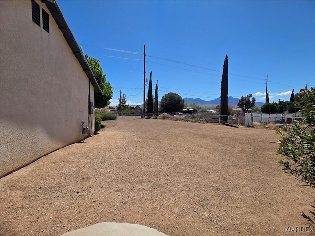 view of yard with a mountain view and fence