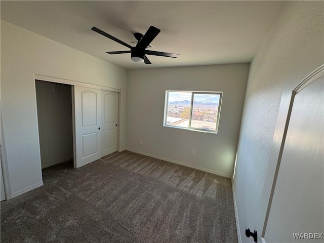 unfurnished bedroom featuring a ceiling fan, a closet, dark carpet, and baseboards