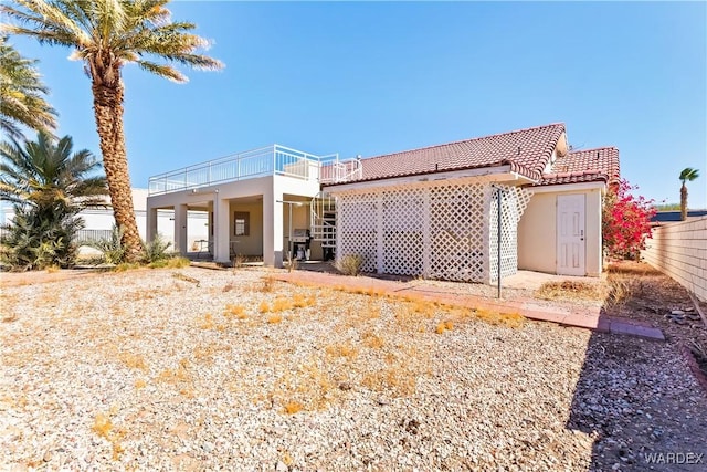 view of front of home featuring a tile roof, fence, and stucco siding