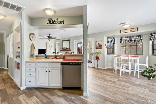 kitchen featuring a sink, light wood finished floors, visible vents, and stainless steel dishwasher