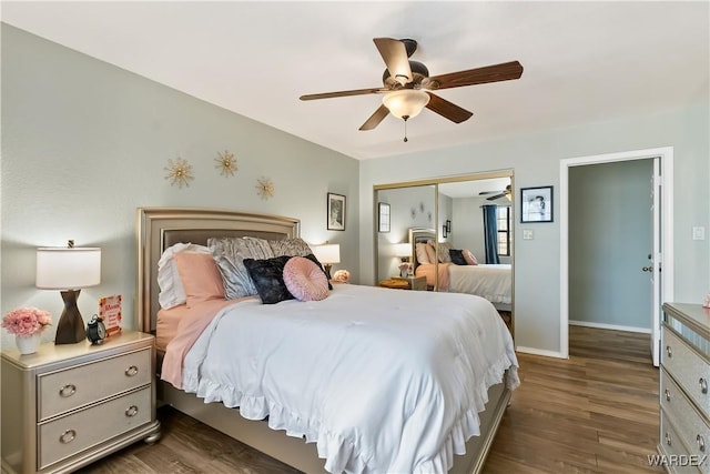 bedroom with dark wood-style flooring, a closet, a ceiling fan, and baseboards