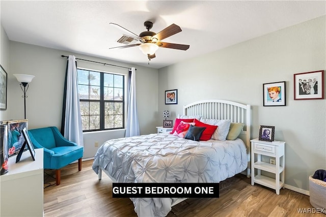 bedroom featuring ceiling fan, wood finished floors, and baseboards