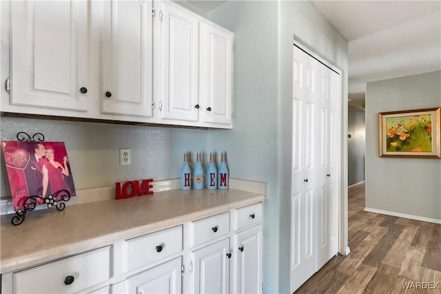 kitchen featuring white cabinets, dark wood-style floors, and light countertops