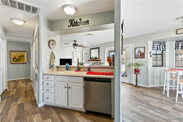 kitchen featuring a sink, visible vents, stainless steel dishwasher, and wood finished floors