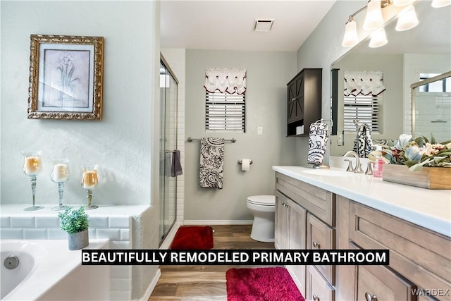 bathroom featuring a stall shower, visible vents, toilet, wood finished floors, and a garden tub