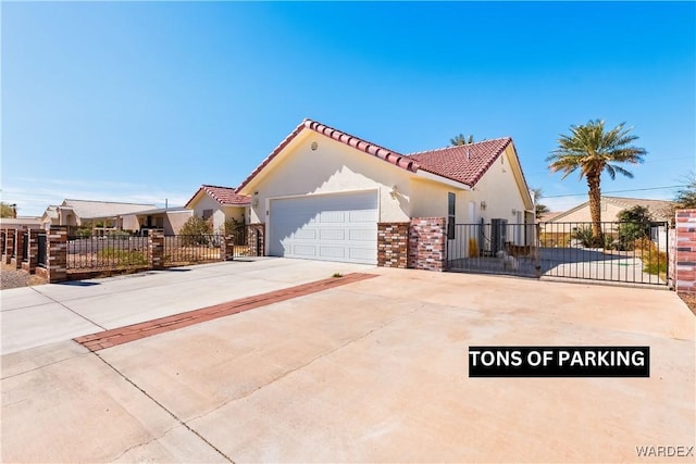 view of property exterior featuring a garage, concrete driveway, a gate, fence, and stucco siding