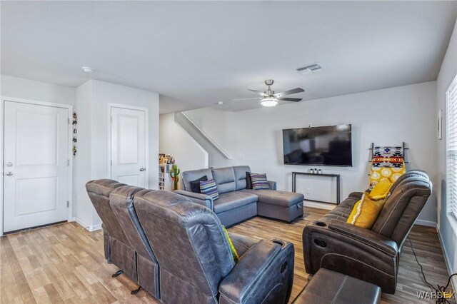 living room featuring baseboards, visible vents, and light wood finished floors